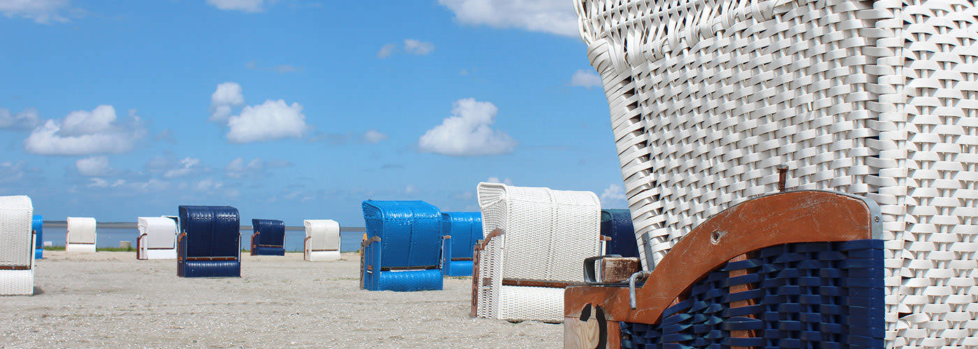 Blaue und weiße Strandkörbe am Nordseestrand von Harlesiel bei Carolinensiel